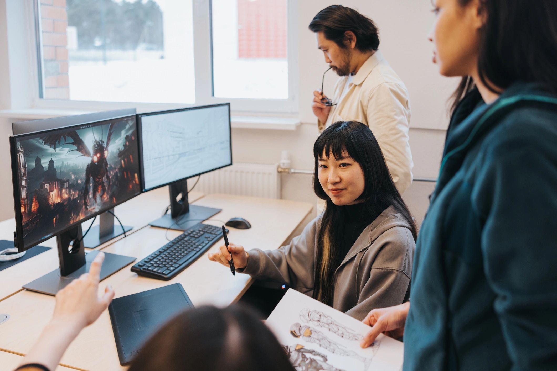 Game developers collaborating at their workstations